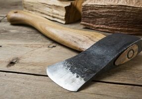 Wooden handle axe lying on wooden table, ready for use