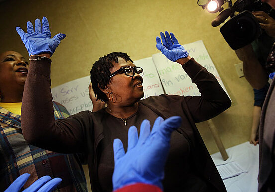 SEIU Holds Ebola Training For Laguardia Airport Workers...NEW YORK, NY - OCTOBER 09:  Mary Moorer leads a class with workers from 
the union 32BJ, many of them airline cabin cleaners, terminal cleaners and wheelchair attendants, participate in a class on how to better protect themselves from infectious diseases in the wake of increased concerns around the Ebola virus on October 9, 2014 in New York City. The infectious disease training classes will be ongoing and teach members how to wear protective clothing and to safely handle potentially harmful body fluids they may come in contact with. It was announced on Wednesday that five airports across the United States will start screening passengers arriving from Ebola-affected countries in West Africa.  (Photo by Spencer Platt/Getty Images)