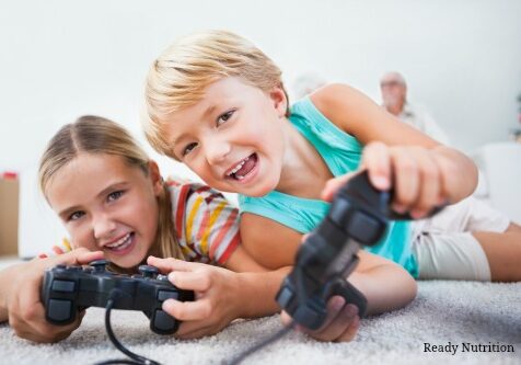 Siblings having fun playing video games on the floor