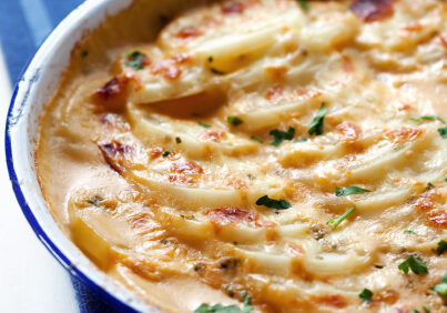 Scalloped potatoes in an old blue enamel bowl.  Shallow depth of field.