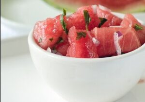 Watermelon salsa with red onion in white bowl