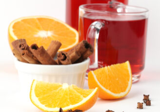 Mulled wine with oranges, cinnamon, anise and clove on white background