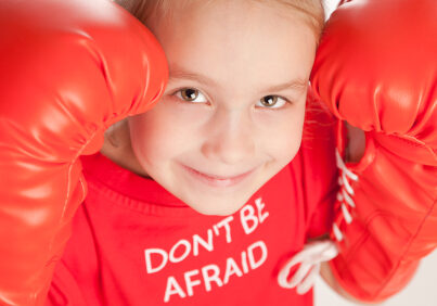 Cute litte girl with attitude wearing red boxing gloves