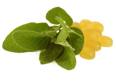 Yellow cough drops with sage leafs over white a background.