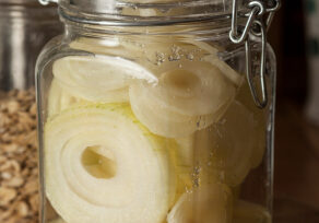 Jar with raw onion slices sprinkled with sugar giving onion syrup, traditional home remedy for cough and cold