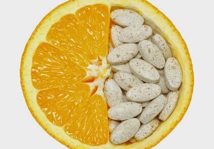 Close up of orange fruit and pills isolated